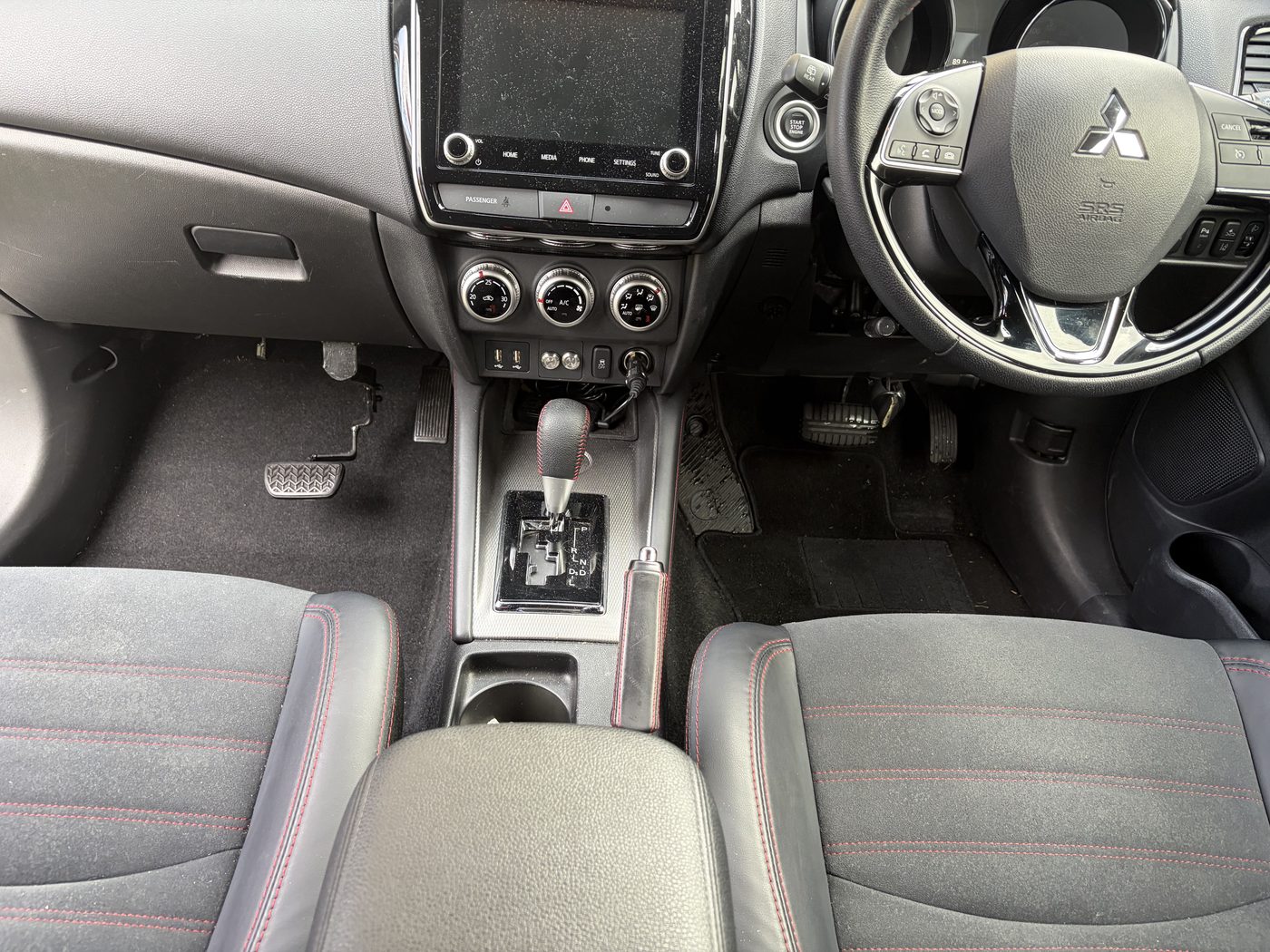 Inside an A1 Driving School dual-controlled car, showing the instructor's own set of pedals on the passenger side