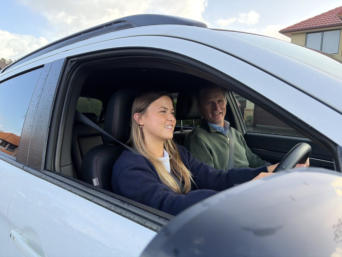 Harald from A1 Driving School sitting calmly beside a smiling learner driver during an Auckland lesson